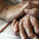 A nurse holds the hands of a person suffering from Alzheimer’s disease on September 21 2009 at the Les Fontaines retirement home in Lutterbach, France